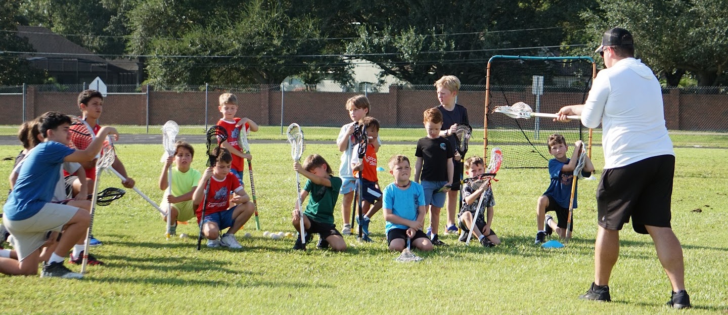 Brantley Bulldogs coach teaching young lacrosse players